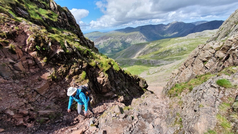 Hiker scrambling up the mountain