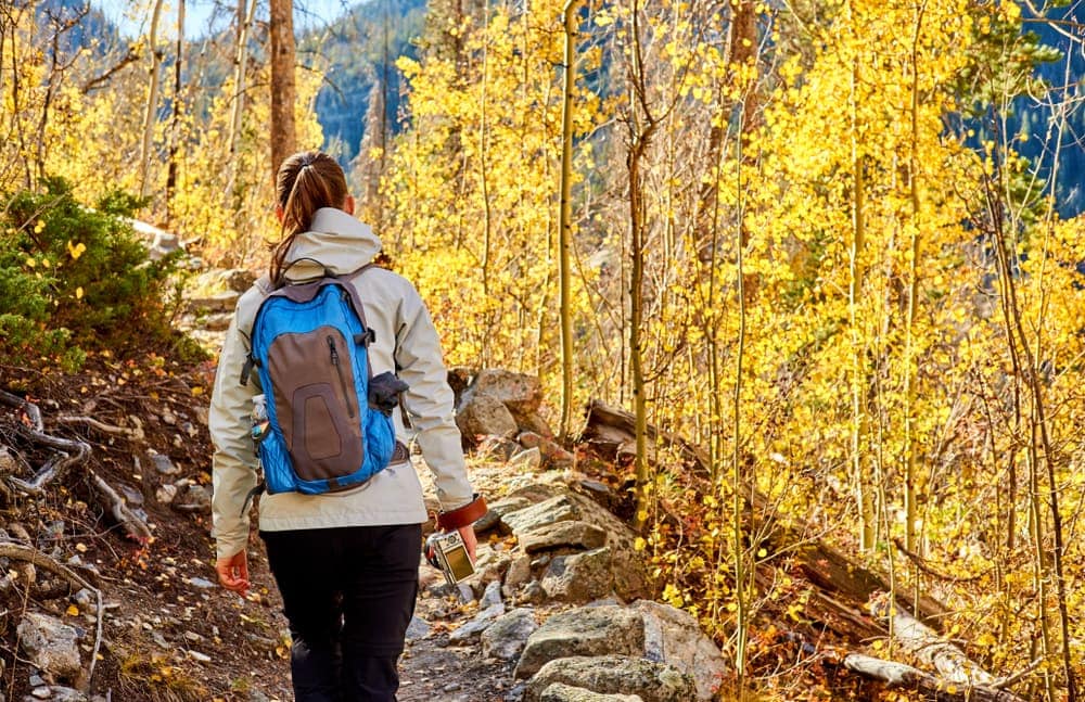 Woman hiking in rocky mountain national park with a right layer of clothing