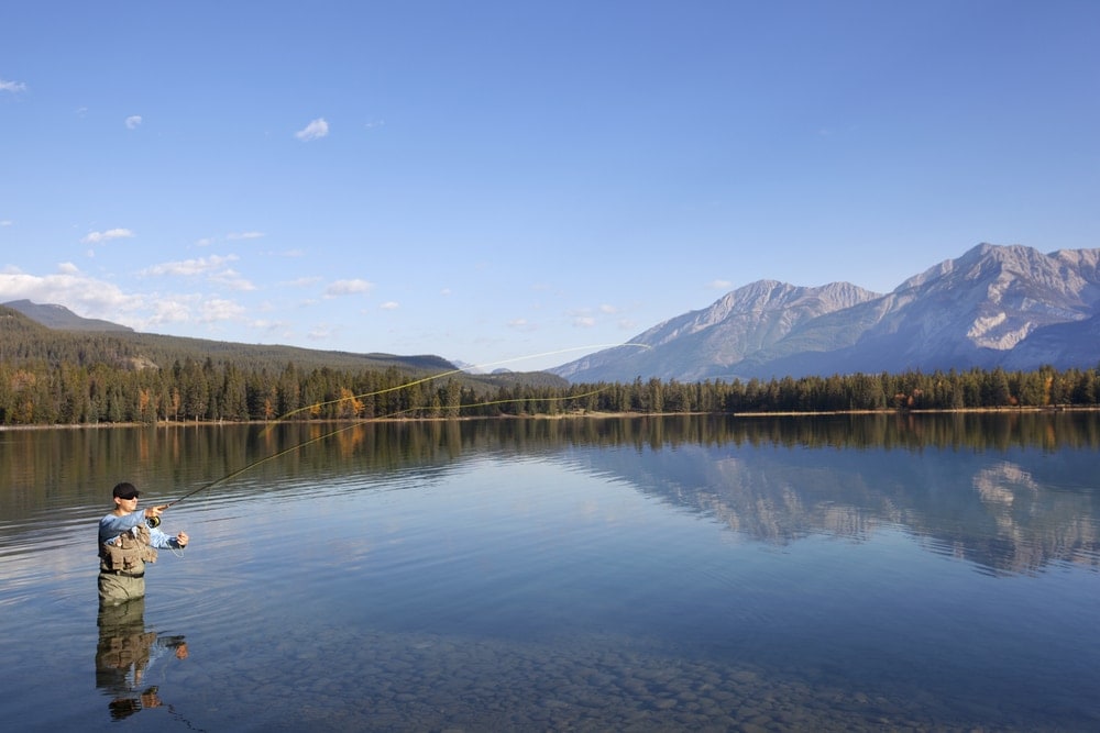 man fishing on a lake in Glacier National park