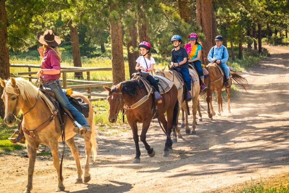 a family doing horseback riding along Glacier National park