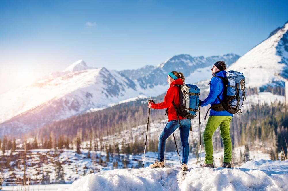 Couple under sunset before hiking in winter