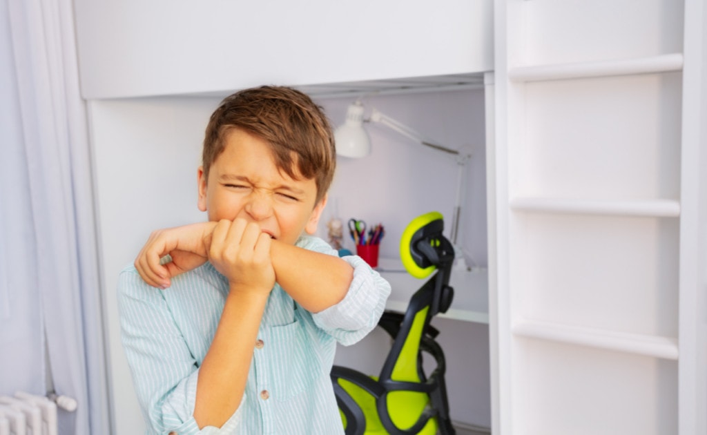 a kid trying to bite his arm