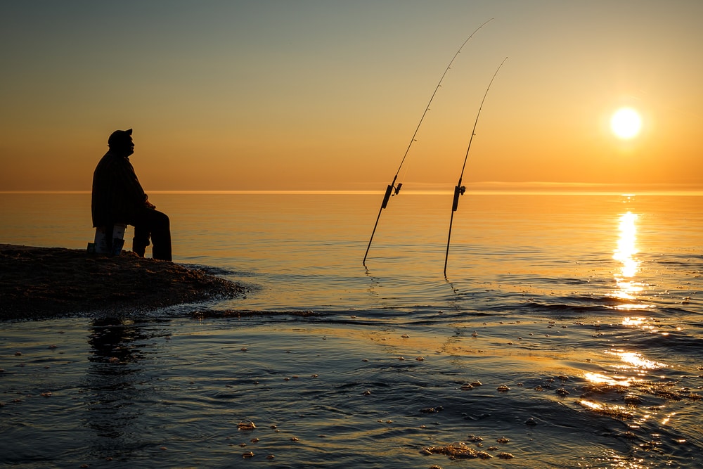 silhouette of a fisherman in Lake superior during sunset