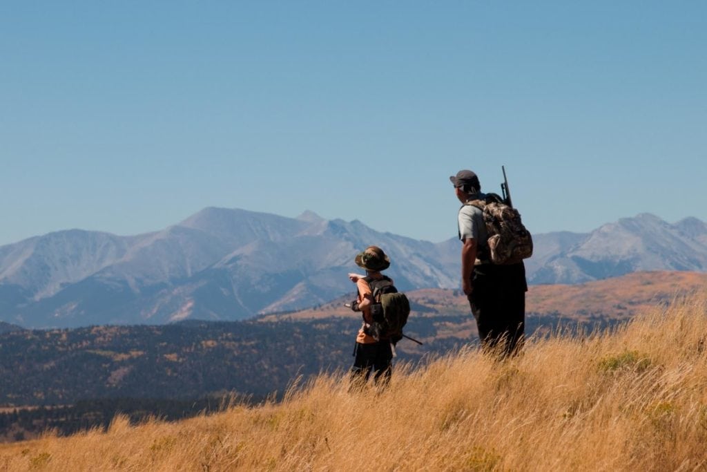 a father and son on a hunting trip in a meadow