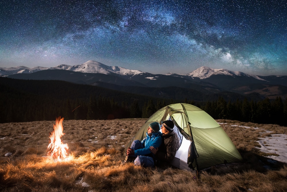 a couple viewing the stars while camping