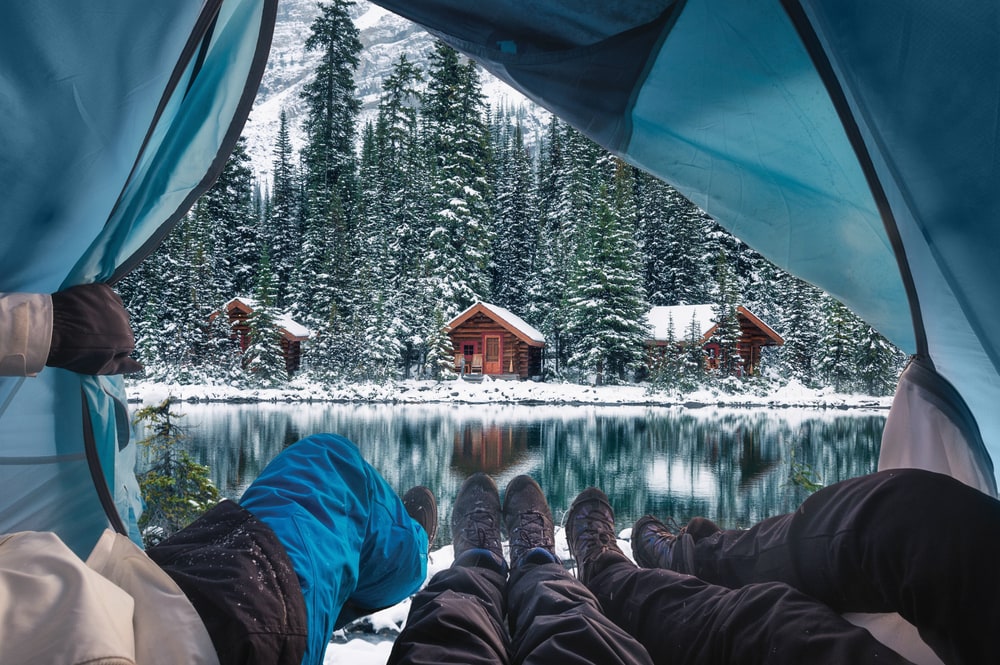overlooking at snow-covered pine trees from a tent