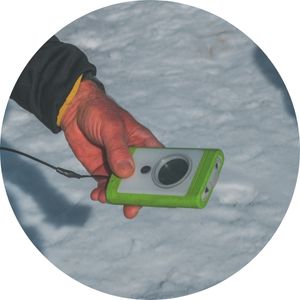 a man holding an avalanche transceiver