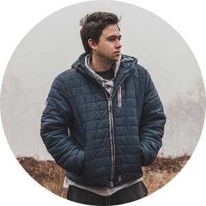 a man wearing a jacket in the wilderness