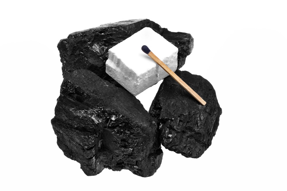 Piece of styrofoam on top of three coals