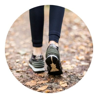 Woman walking with her shoes in the forest