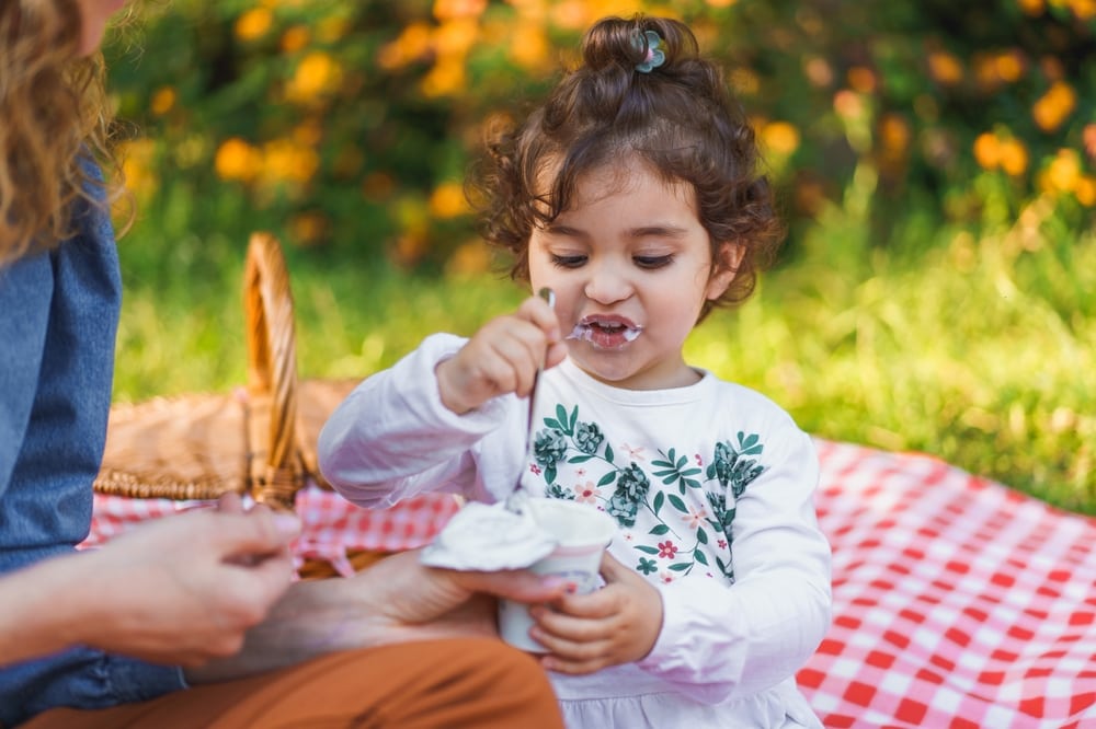 Kid eating yogurt in camping