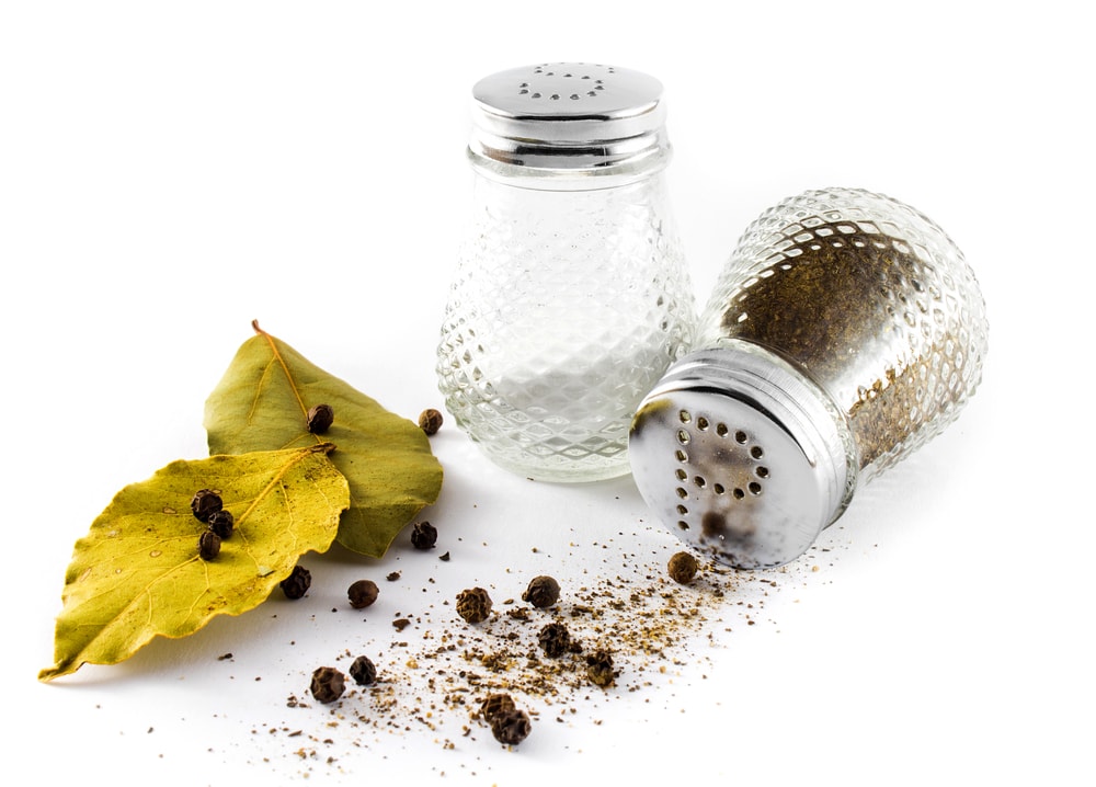 Salt and Pepper with a leaf on white background