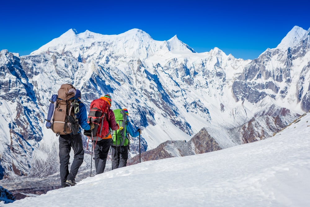 Group of hikers hiking a mountain full of snow