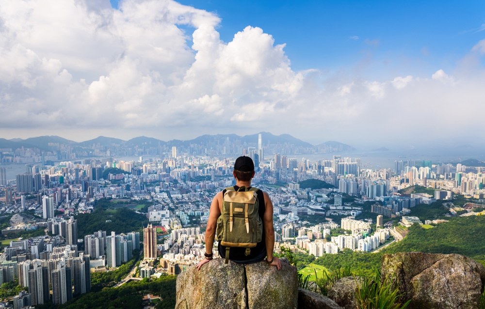 Hiker at the mountain on top of an urban area