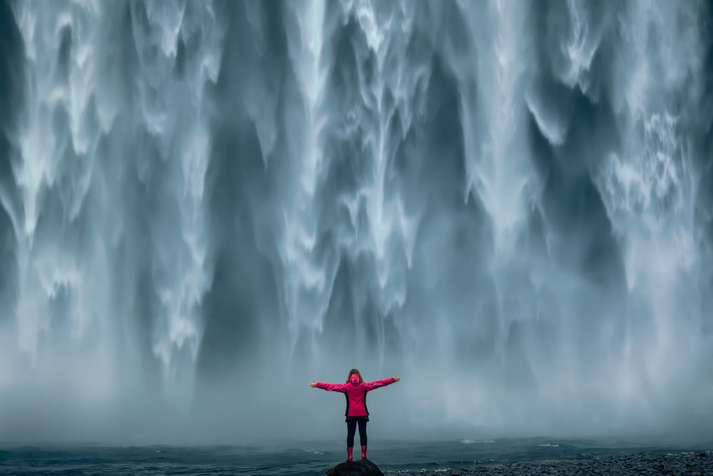 Woman below the waterfalls