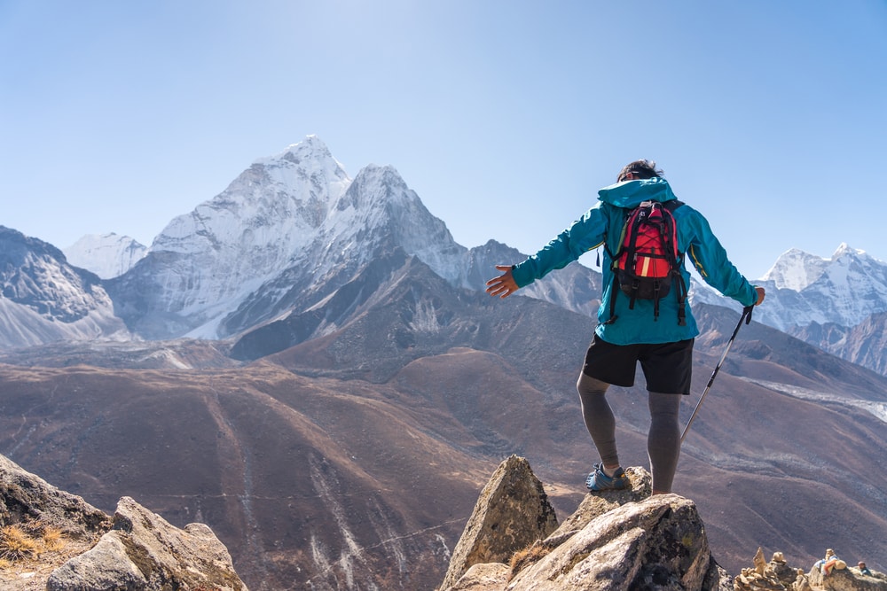 A hiker on top of the summit of a mountain
