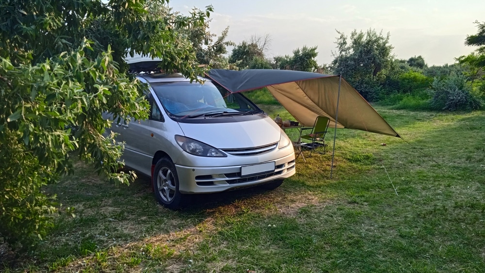 A silver SUV with extended awning